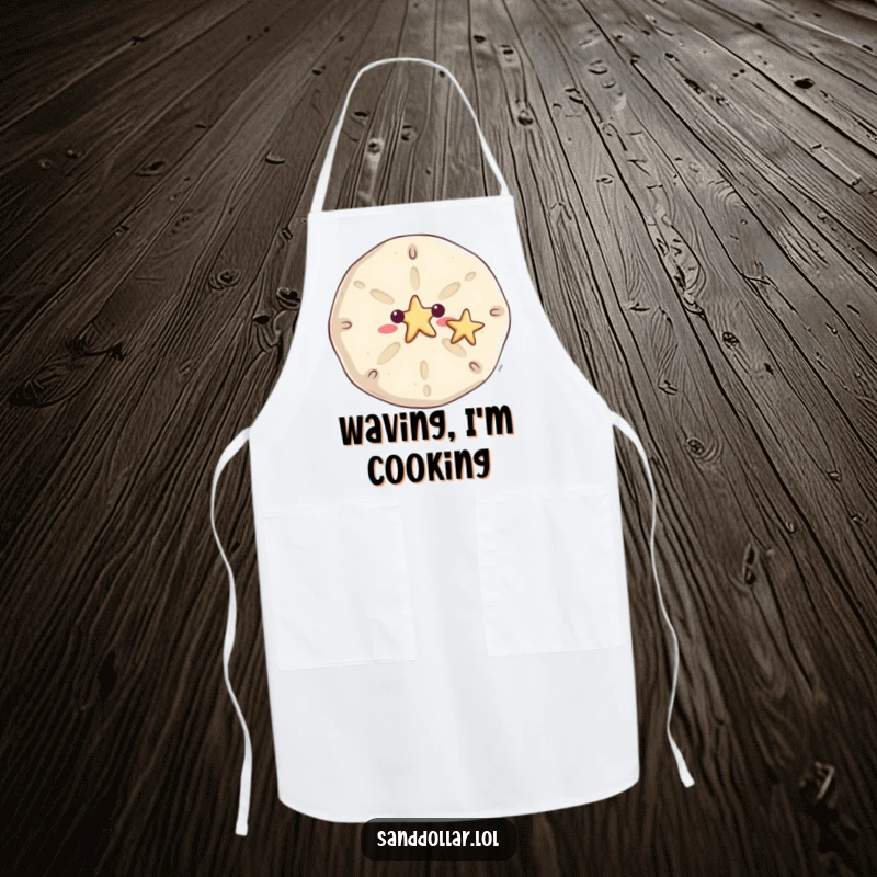 Funny sand dollar apron for cooking, with a smiling sand dollar waving a tiny starfish, bringing beachy greetings to the kitchen.